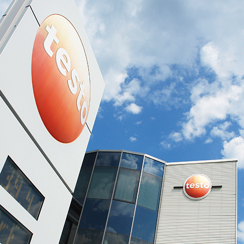 Testo building with logos under a blue sky