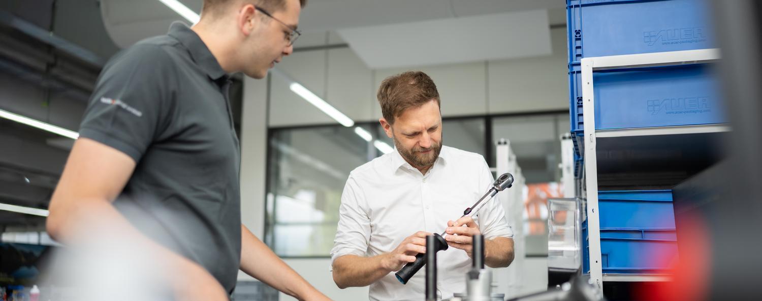 Statistical process control (SPC) Two men are calibrating a torque wrench.