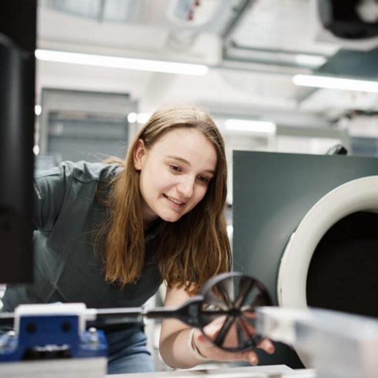 An employee is calibrating a vane wheel in an open wind tunnel