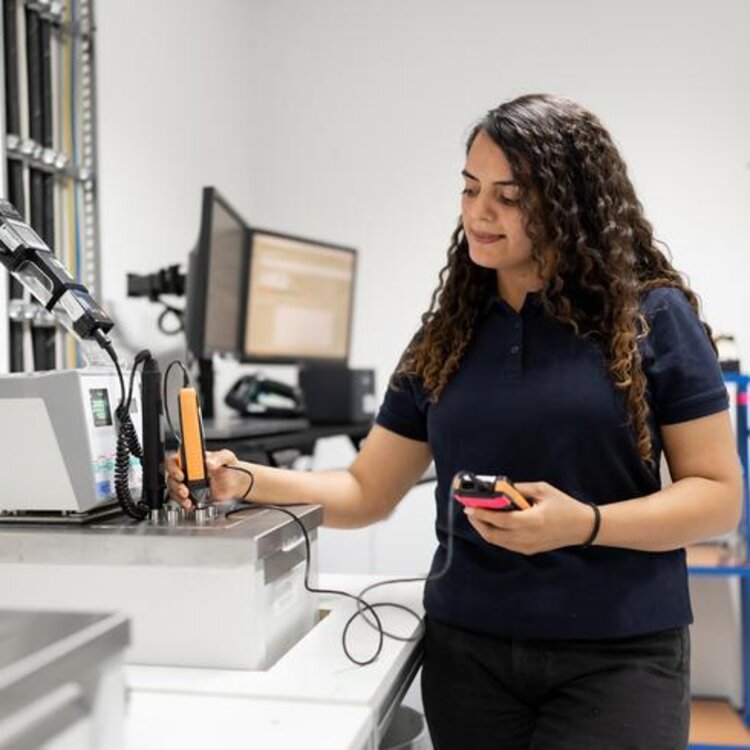 An employee is calibrating a Testo temperature probe in an immersion tank